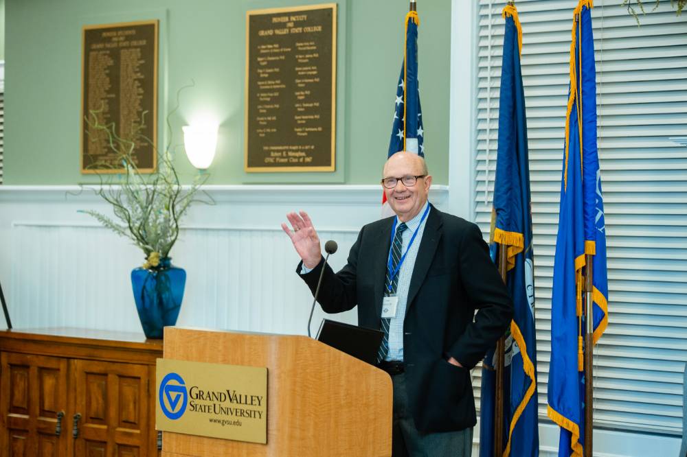 An alumnus from the class of '68 stands at the podium, while waving to the crowd at the Reunion Dinner.